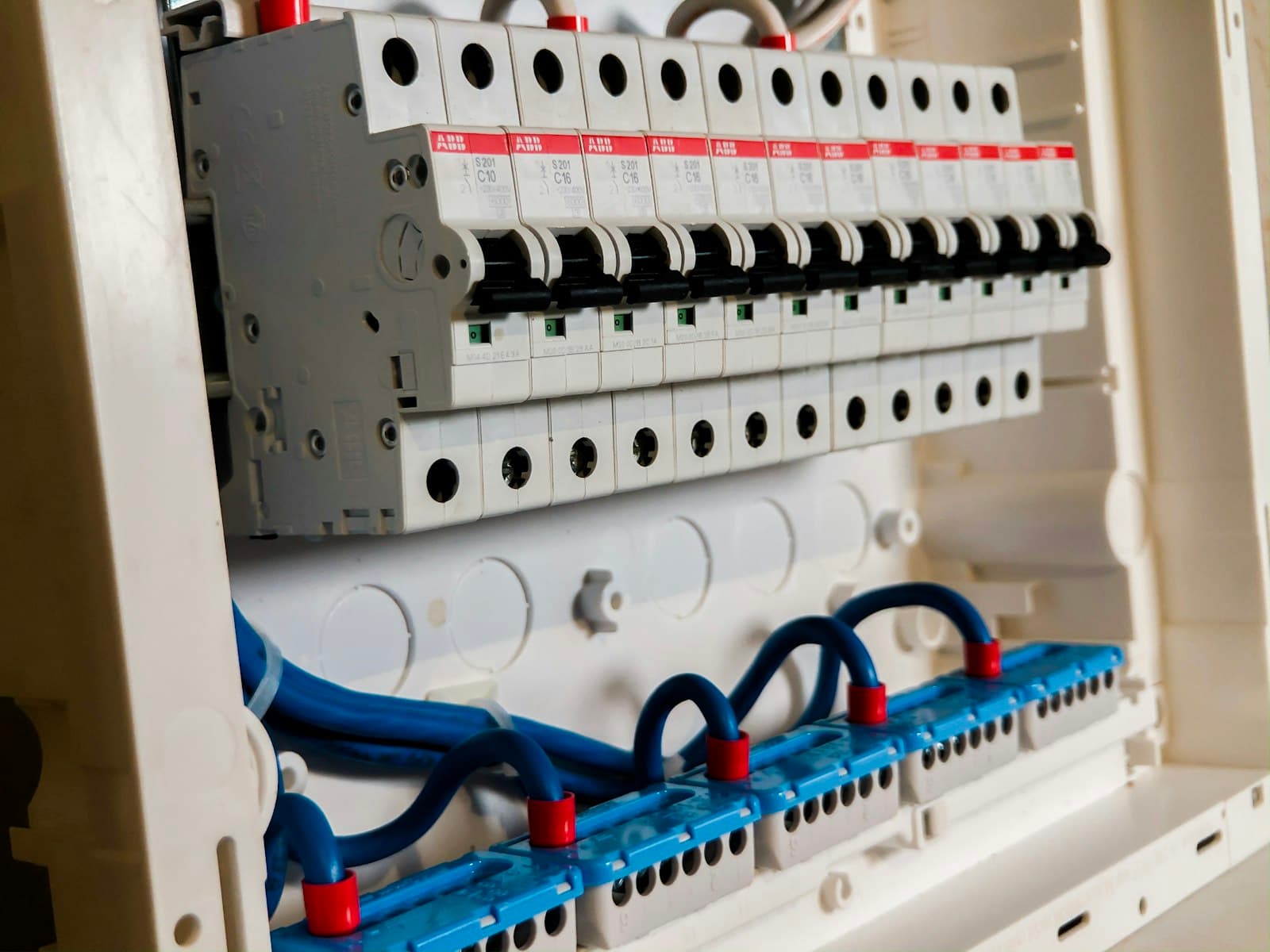 Row of miniature circuit breakers in a distribution board.