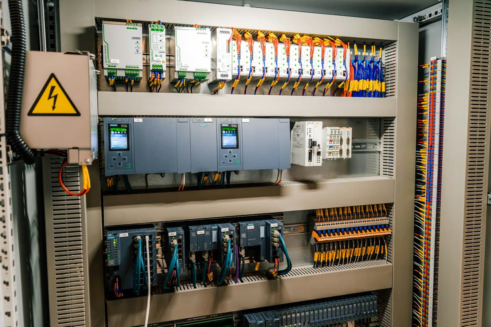 Control panel with PLC, relays and terminal blocks.