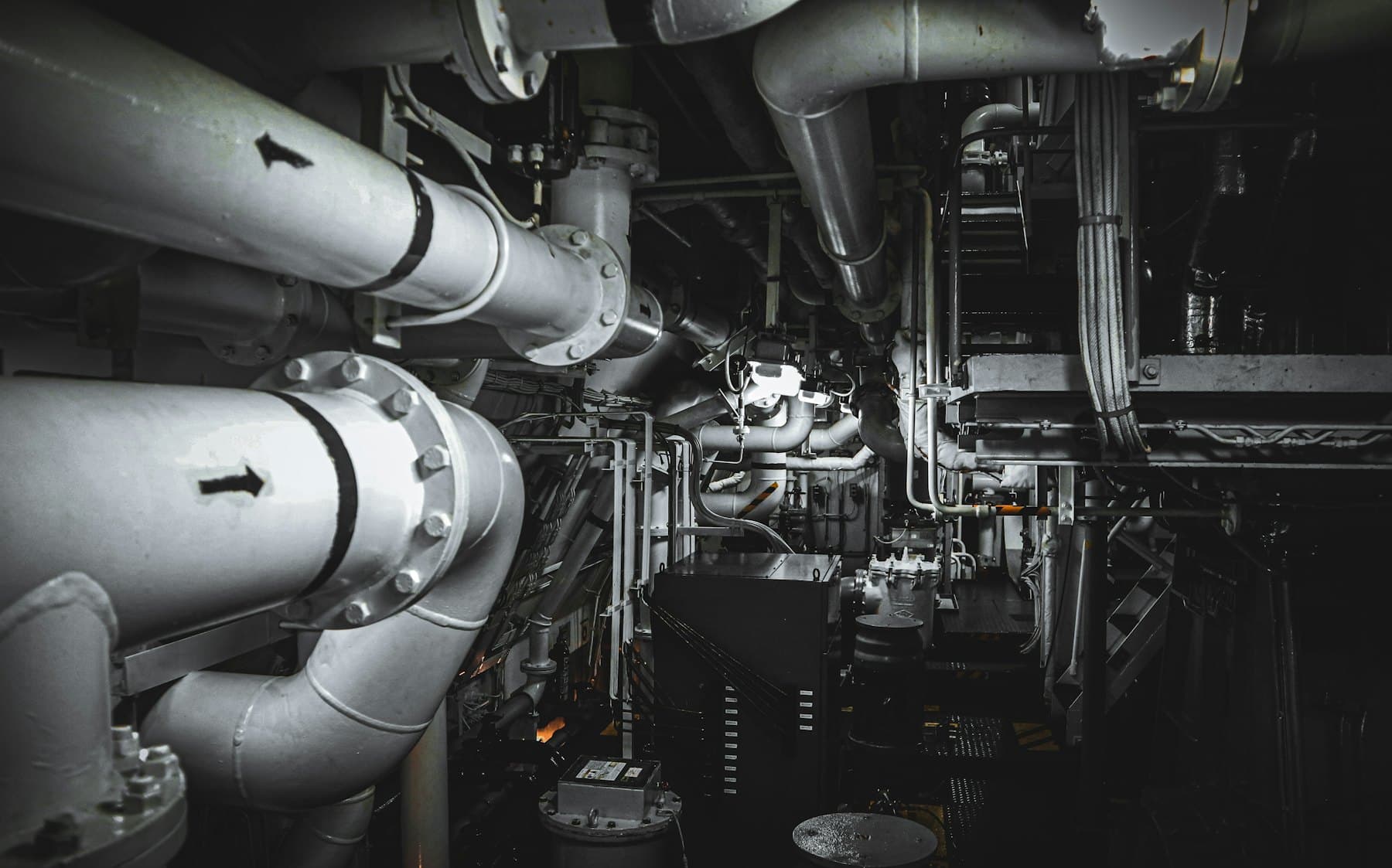 Pipework and machinery in a ship's engine room.