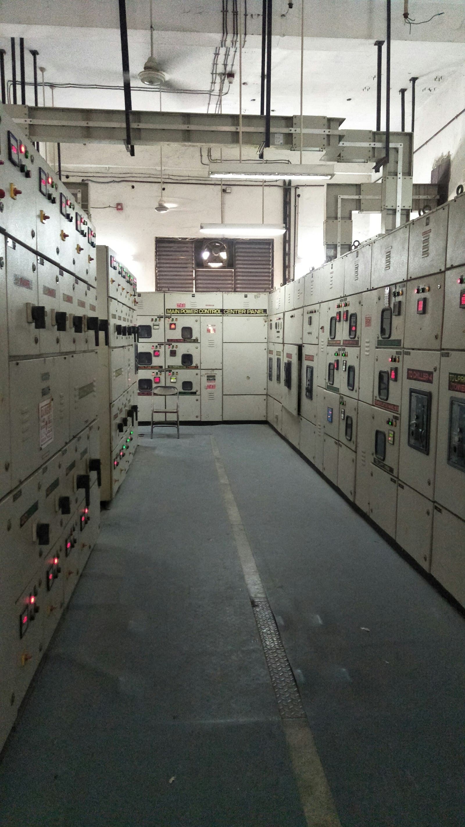 Aisle between switchgear panels in an electrical room.