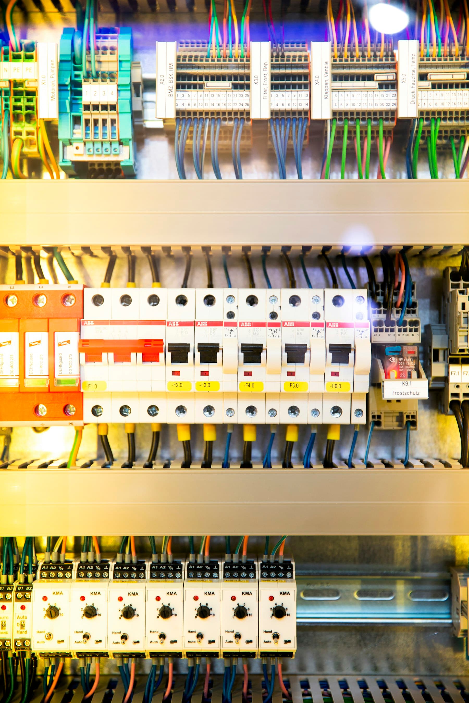 Distribution board with rows of circuit breakers and wiring.